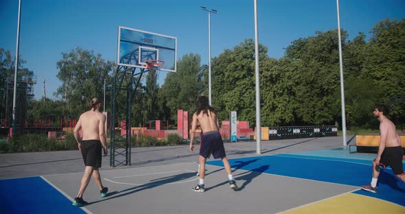 Basketball Players with Bare Torsos Play Basketball on Court