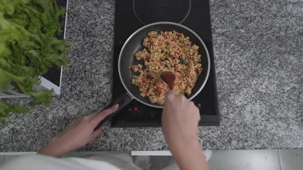 Person Cooking Healthy Brown Rice Meal Using An Electric Stove