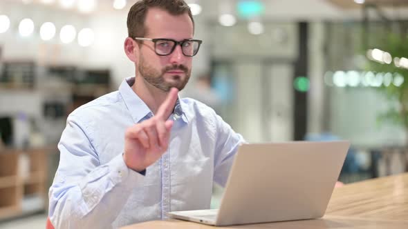 Serious Businessman with Laptop Saying No with Finger Sign