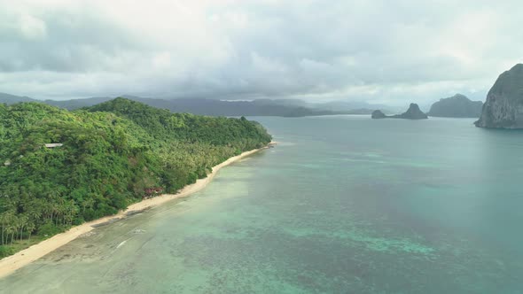 Aerial view of a tropical island in Palawan, Philippines and its white beach. Small rocky islands in