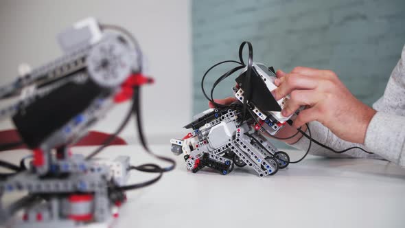 assembling a model of robotics from plastic toy blocks