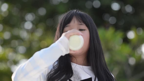 Cute Asian Child Drinking Milk From Bottle