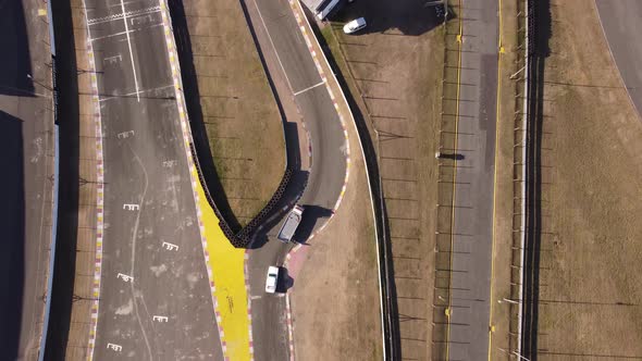 Aerial top down shot of trucking towing away race car after accident on racetrack