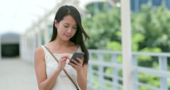 Asian Woman look at the smart phone in city