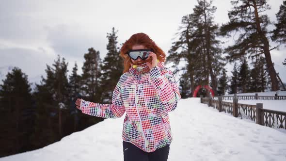 Happy Girl in Skiing Equipment Runs and Smiles of Snowy Mountains and Forest