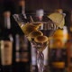Closeup of a Martini Glass with Olives in the Bar the Glass Slowly Rotates - VideoHive Item for Sale