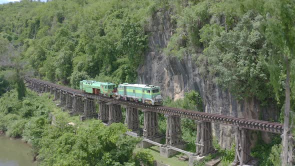 Aerial view of Thai local old classic train on railway on River Kwai Bridge