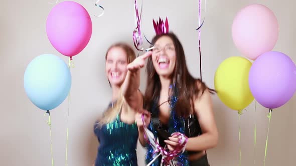 Slow motion of two attractive girls dancing in photo booth