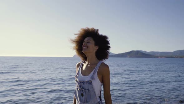 Slow motion shot of young smiling woman shaking her head on the beach