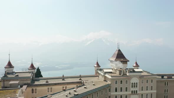 Flying past tower on top of Swiss hotel roof and revealing lake Geneva