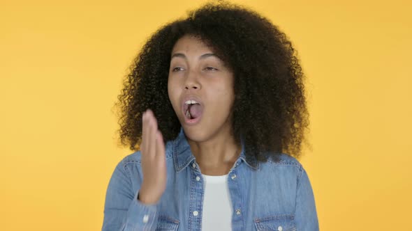 Sleepy African Woman Yawning, Yellow Background 