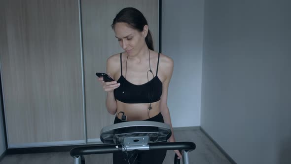 Female Athlete Uses Smartphone During Break