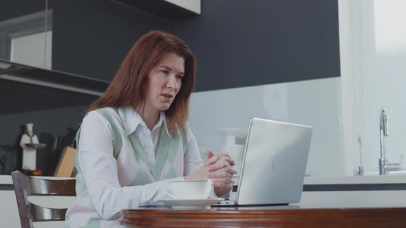 Businesswoman Having Online Meeting on Laptop in Kitchen