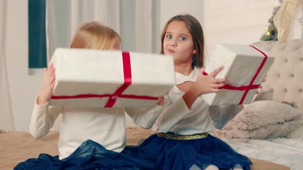 Two Little Girls Holding Boxes of Christmas Presents