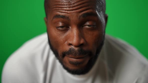 Front View Headshot of Confident Sweating African American Sportsman Looking at Camera at Chromakey