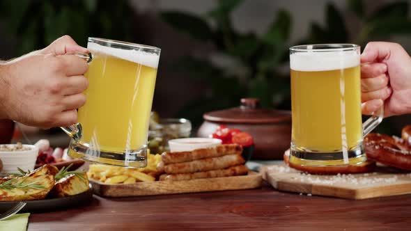 Clinking with Frothy Beer in Glasses Closeup