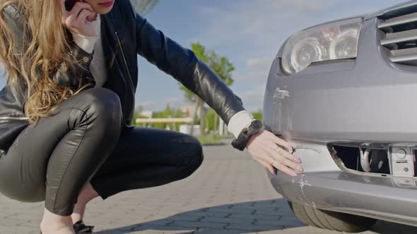 Woman Looking At Broken Car After Accident