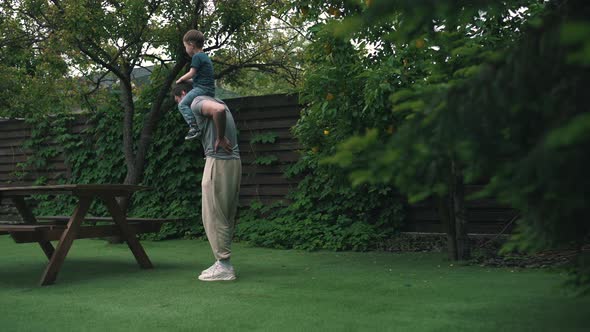 a Man Felt Back Pain Playing with a Child in the Yard