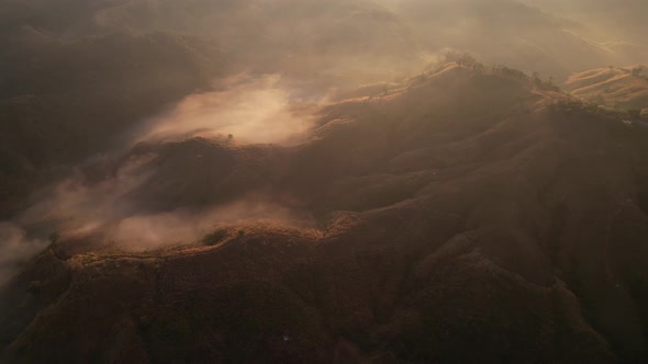 Aerial view of sunrise with fog above mountains