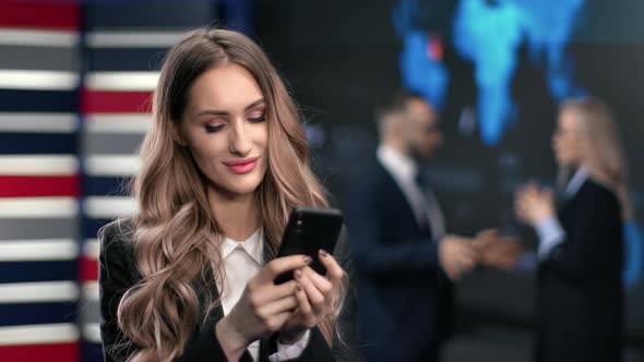 Pretty Young Blonde Business Woman Chatting Surfing Internet Use Smartphone at Hi Tech Office