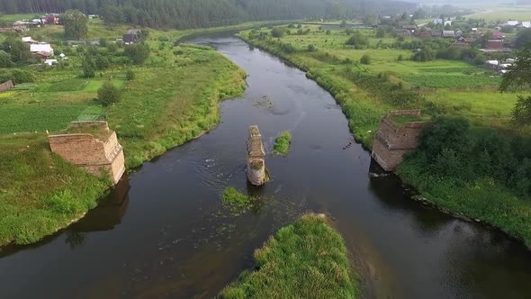 Aerial View of The Remains of A Destroyed Brick Bridge Over the River