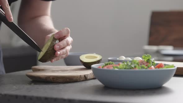 Slow Motion Man Make Salad with Kale Mozzarella Avocado and Cherry Tomatoes Cut Avocado