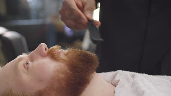 Barber Brushing Beard of Male Client