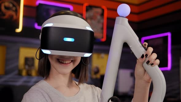 Teen Girl Wearing Virtual Reality Headset Holding Controllers in Hands