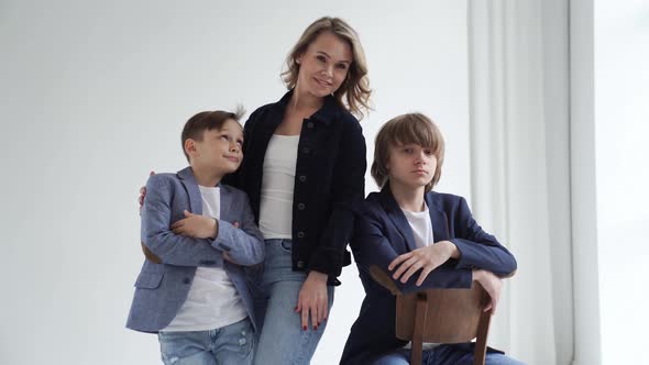 A Mother with Two Sons in Blue Clothes Poses for a Photo Shoot