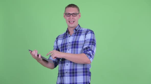 Happy Young Hipster Man Talking While Using Digital Tablet