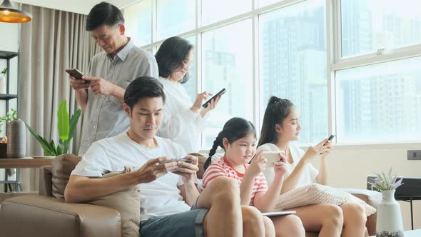 Happy young asian big family relaxing on couch with adorable small daughter