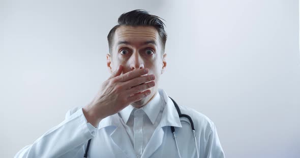 Shocked Man Doctor with Sudden News Closes From Fright Over White Background