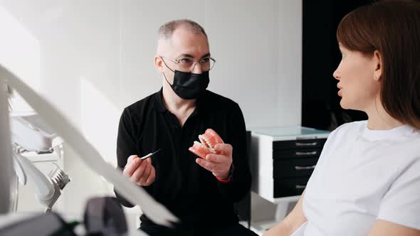 Dentist and Patient Discuss Treatment Plan Using Dental Models