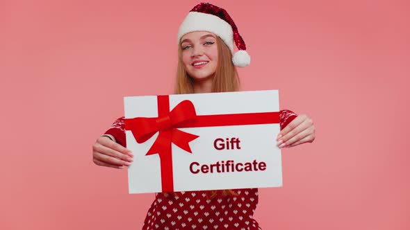 Funny Girl Wears Red New Year Sweater and Hat Presenting Card Gift Certificate Coupon Winner Voucher
