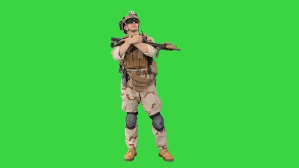 Tired American Soldier with a Rifle Standing on a Green Screen, Chroma Key