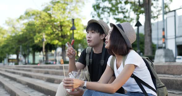 Couple eating sausage at the park