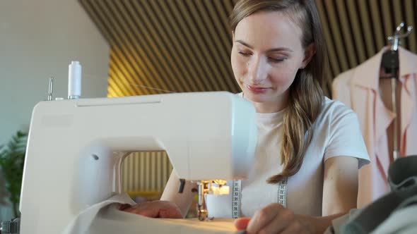 Woman Seamstress Sitting and Sews on Sewing Machine