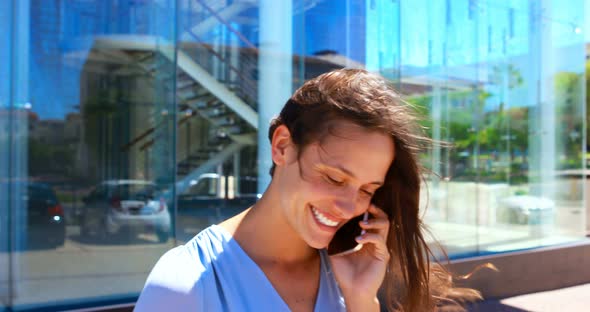 Woman having coffee while talking on mobile phone 4k