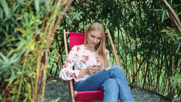 Young Woman Using Smartphone in Plant Gazebo.
