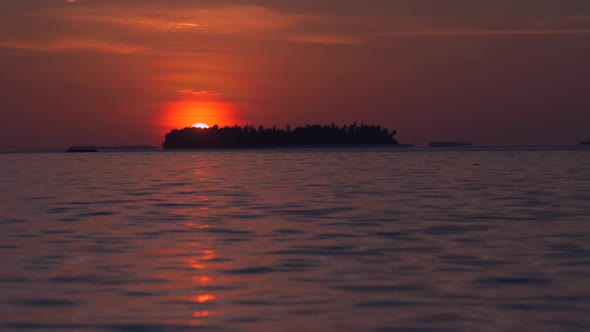 View of a scenic tropical island at sunset in the Maldives.