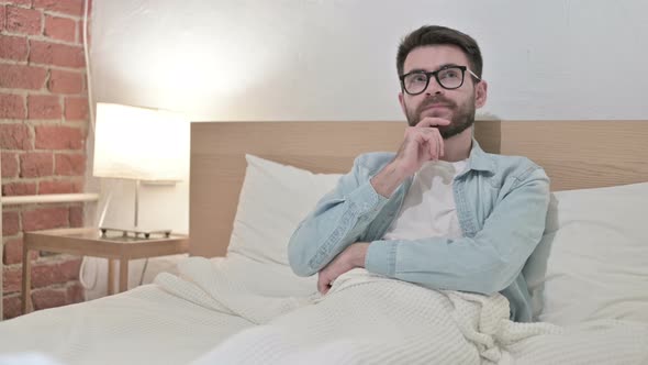 Thoughtful Young Male Designer Thinking in Bed