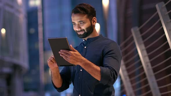 Professional Indian Business Man Using Digital Tablet Outdoors in Night City