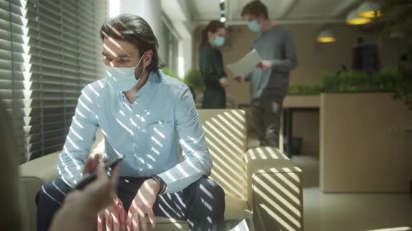 A Young Businessman is Working with His Colleague and Discussing a Project