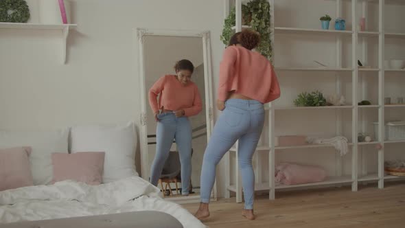 African Woman Trying To Squeeze Into Tight Jeans