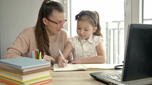 Young Woman Is Helping Her Little Daughter with Homework. Back To School.