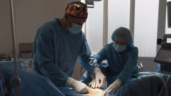 A Team of Surgeons Stitches the Patient's Body