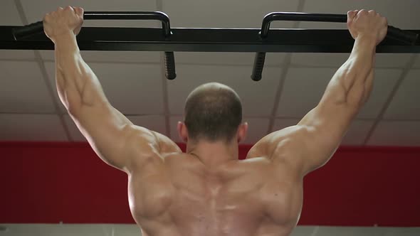 Bodybuilder With Perfect Muscular Body Doing Pull-Ups, Preparing for Competition