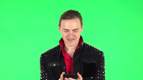 Happy Guy Texting on His Phone. Green Screen