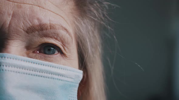 Eye of an Senior Woman with Wrinkled Skin Under Medical Mask