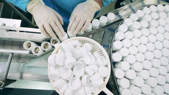 Tubs with Pills are Getting Closed By a Pharma Worker